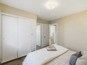 Bedroom with carpet flooring, a closet, and ensuite bath