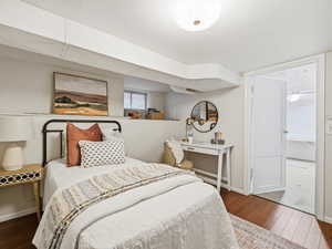 Bedroom with hardwood / wood-style flooring and baseboards