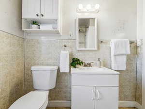 Full bath with tile walls, vanity, and a shower with shower curtain