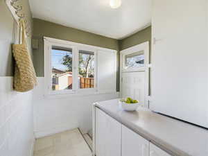 Laundry area featuring wainscoting and tile walls