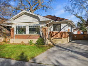 Bungalow featuring brick siding