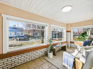 Sunroom / solarium featuring tile patterned flooring and wooden ceiling