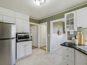 Kitchen featuring appliances with stainless steel finishes, white cabinetry, and dark countertops