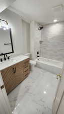 Full bathroom with vanity, bathing tub / shower combination, light marble finish flooring, and a textured ceiling