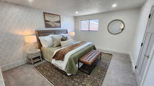 Bedroom featuring carpet flooring, wallpapered walls, a textured ceiling, and recessed lighting