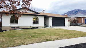 Single story home featuring brick siding, a chimney, driveway, and a garage