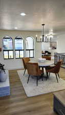 Dining area with a textured ceiling, recessed lighting, light wood-type flooring, and a chandelier