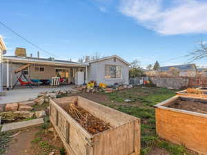 Back of house featuring a vegetable garden and a patio