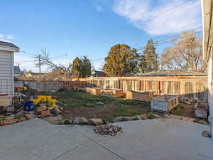 Fenced backyard featuring a patio area and a garden