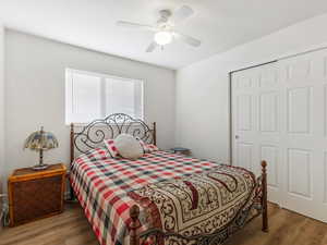 Bedroom featuring wood finished floors, ceiling fan, and a closet