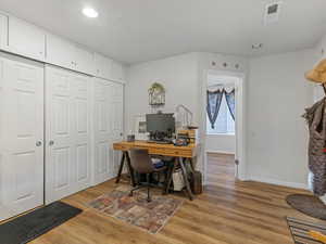 Office area featuring light wood-style flooring and recessed lighting