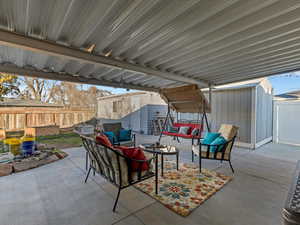 Fenced backyard with a storage shed, an outdoor living space, and a patio area