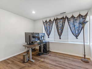 Office area with light wood-style flooring and recessed lighting