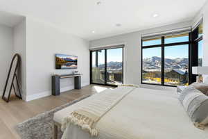 Bedroom with light wood-style floors, access to outside, and recessed lighting