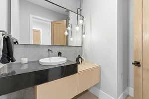 Bathroom with vanity and tasteful backsplash