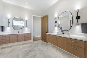 Full bath with two vanities and light marble finish floors