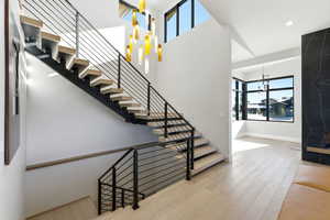 Stairs featuring a chandelier and wood finished floors
