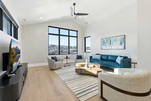 Living room featuring light wood finished floors, high vaulted ceiling, a ceiling fan, and recessed lighting