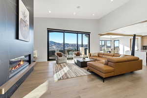 Living room featuring recessed lighting, a fireplace, light wood-type flooring, and a mountain view