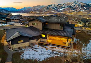 View of front of home with a metal roof, stone siding, a standing seam roof, and a mountain view