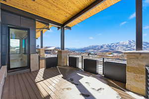 Wooden deck featuring a mountain view, a patio area, and area for grilling