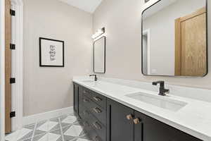 Bathroom with double vanity and light tile patterned floors