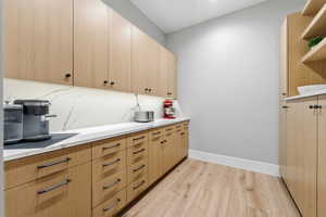 Kitchen featuring light wood-style flooring, light brown cabinets, open shelves, and modern cabinets