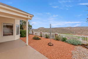 Fenced backyard with a mountain view and a patio area