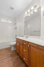 Bathroom with vanity, light wood-type flooring, and shower / bathtub combination