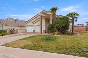 View of front of home with stucco siding, driveway, a front lawn, a garage, and a tiled roof