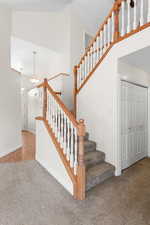 Staircase featuring carpet floors and a towering ceiling