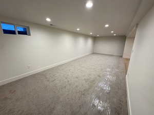 Finished basement with recessed lighting and carpet