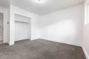 Unfurnished bedroom with a closet and carpet flooring