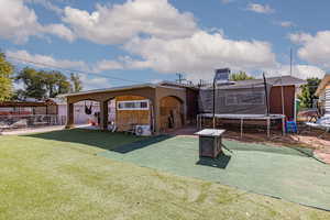 Rear view of property featuring a trampoline