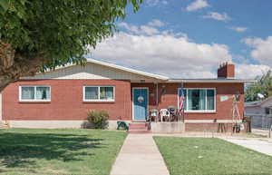 Ranch-style house featuring a chimney and brick siding