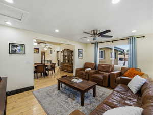 Living area featuring light wood-type flooring, a ceiling fan, recessed lighting, and attic access