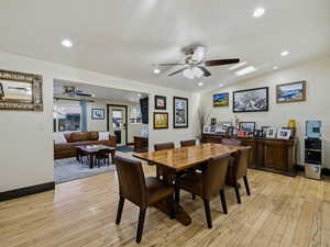 Dining room with ceiling fan, light wood finished floors, lofted ceiling, and recessed lighting