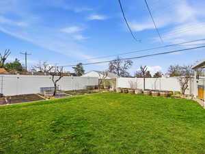 Fenced backyard featuring a garden