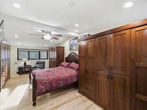 Bedroom with light wood-style floors, ceiling fan, and recessed lighting