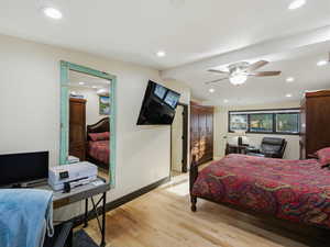 Bedroom featuring light wood finished floors, a ceiling fan, recessed lighting, and an office area
