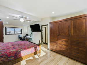 Bedroom featuring an office area, light wood-style floors, a ceiling fan, and recessed lighting