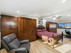 Bedroom with light wood finished floors, recessed lighting, a desk, and a ceiling fan