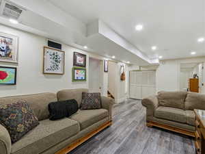 Living area featuring wood finished floors, stairway, and recessed lighting