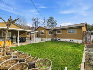 Rear view of property with a garden, a hot tub, a patio, stucco siding, and a shingled roof