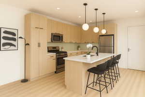 Kitchen with appliances with stainless steel finishes, light brown cabinetry, light countertops, and recessed lighting
