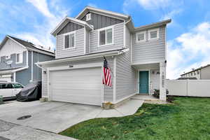 View of front of house featuring board and batten siding, an attached garage, and concrete driveway