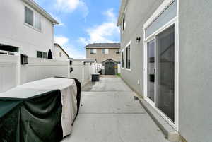 Fenced backyard with a shed, a patio area, and a residential view