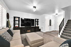 Living room featuring stairs and baseboards