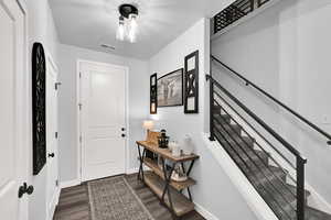Entryway featuring dark wood finished floors and stairway