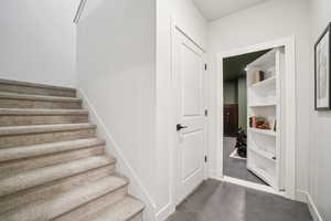 Staircase with finished concrete flooring and baseboards